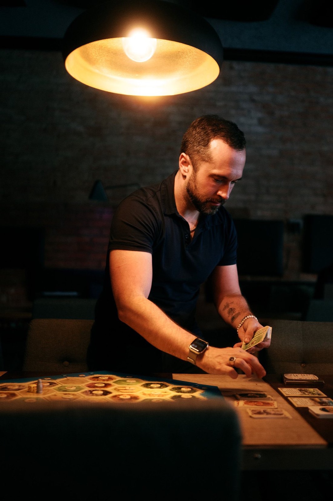 brenen setting a game table under a warm lamp